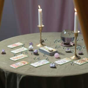 A magical tarot reading table set with lit candles, crystals, and tarot cards suggesting mysticism.