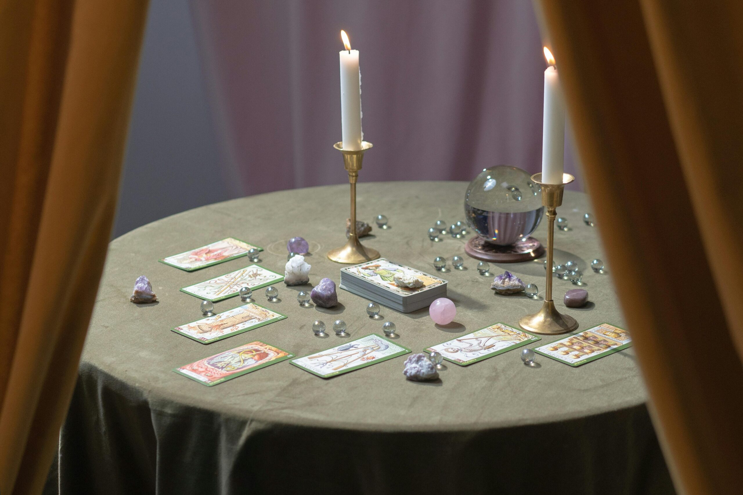 A magical tarot reading table set with lit candles, crystals, and tarot cards suggesting mysticism.